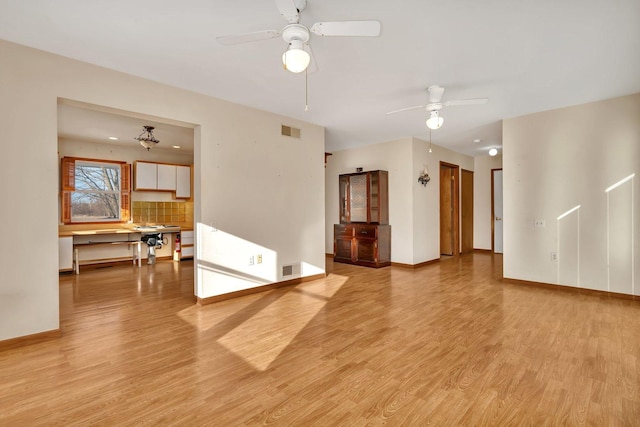 unfurnished living room featuring ceiling fan and light hardwood / wood-style flooring