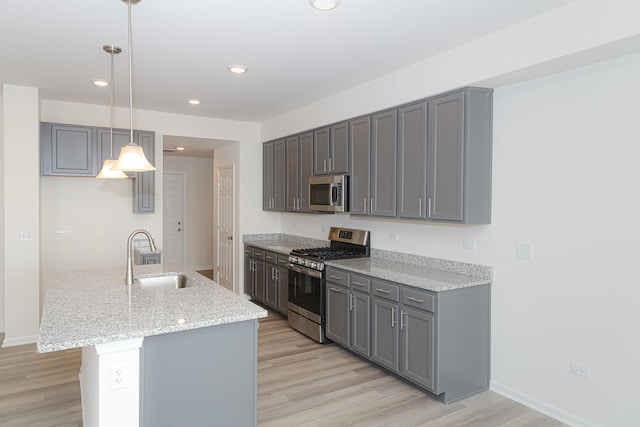 kitchen featuring gray cabinetry, sink, stainless steel appliances, and hanging light fixtures