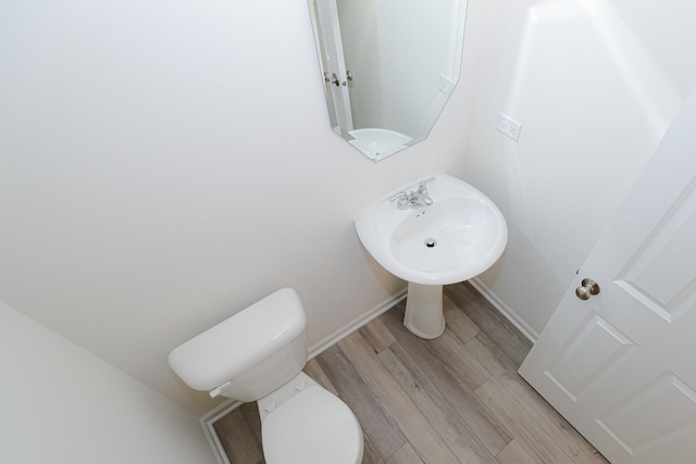 bathroom with hardwood / wood-style floors and toilet