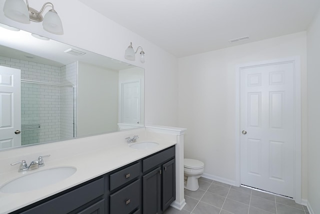 bathroom featuring tile patterned floors, toilet, vanity, and walk in shower