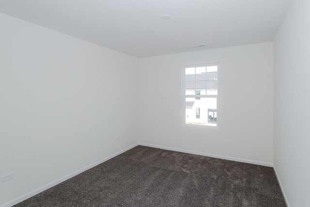 unfurnished room with dark colored carpet