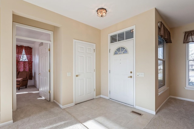 foyer entrance with light carpet and plenty of natural light