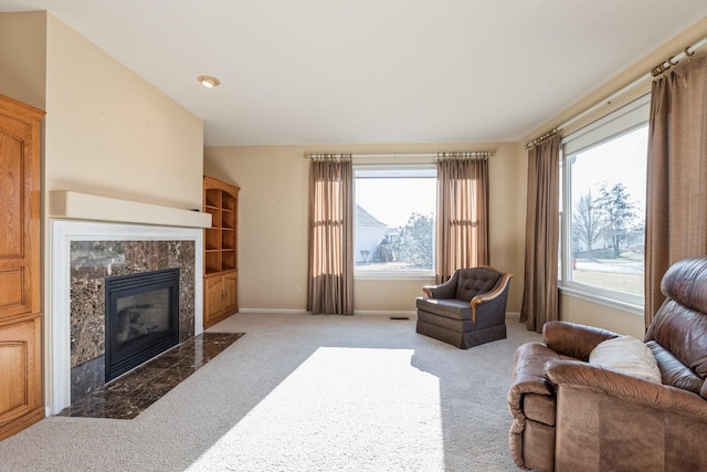 carpeted living room with a high end fireplace