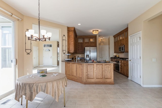 kitchen featuring stainless steel appliances, sink, hanging light fixtures, kitchen peninsula, and a chandelier