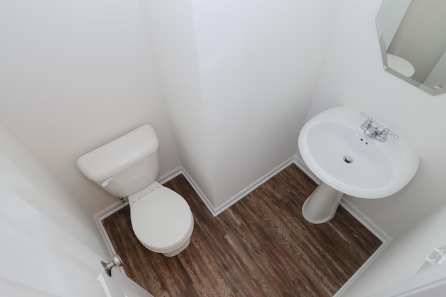 bathroom with hardwood / wood-style floors, toilet, and sink