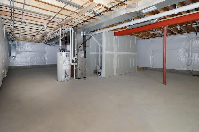 basement with electric panel, heating unit, and water heater