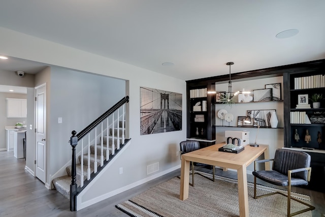 office area with hardwood / wood-style floors and an inviting chandelier