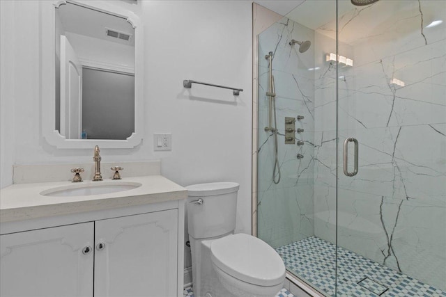 bathroom featuring toilet, a shower with shower door, and vanity