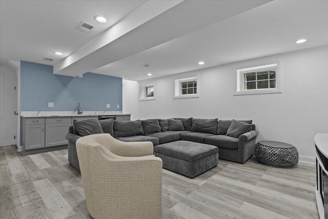 living room with light wood-type flooring and sink