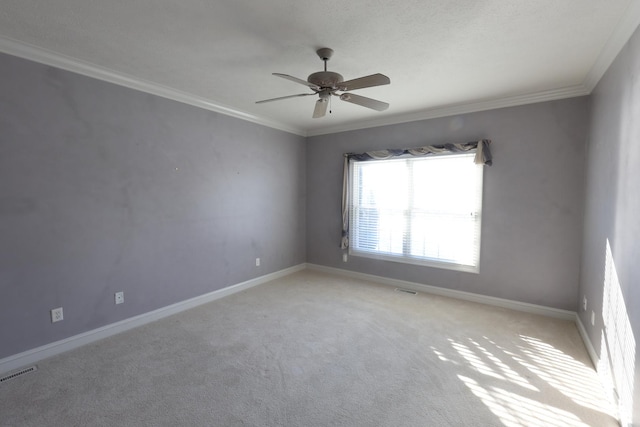 spare room featuring ceiling fan, ornamental molding, and light carpet