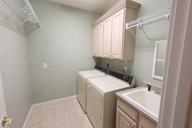 laundry room with light tile patterned floors, washing machine and dryer, cabinets, and sink