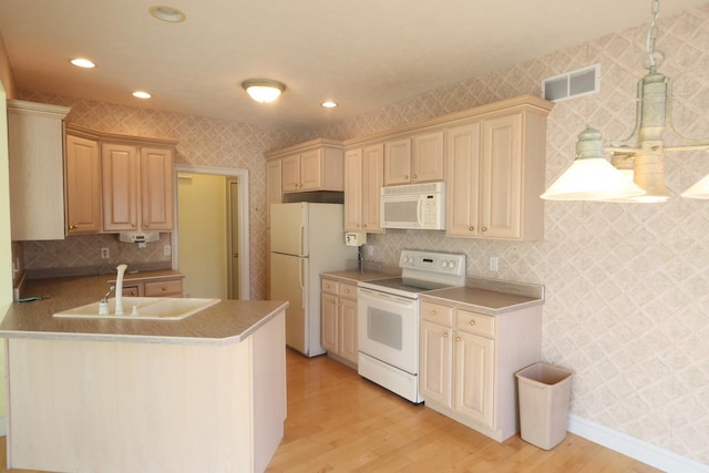 kitchen featuring sink, light brown cabinets, white appliances, light hardwood / wood-style floors, and kitchen peninsula