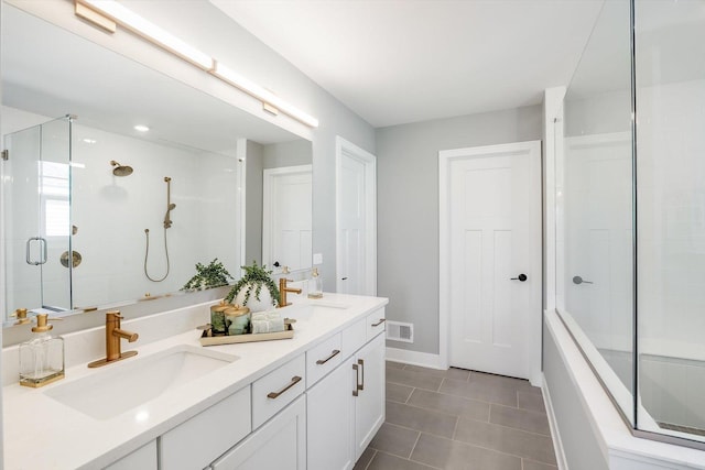 bathroom featuring tile patterned flooring, vanity, and a shower with shower door