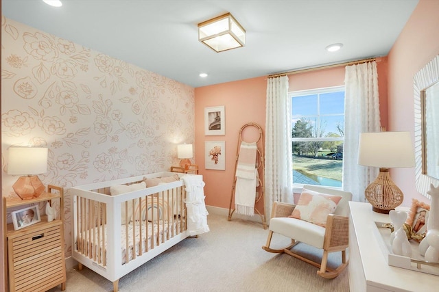 bedroom featuring carpet and a nursery area