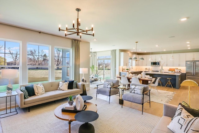 living room with sink, light hardwood / wood-style flooring, and a chandelier