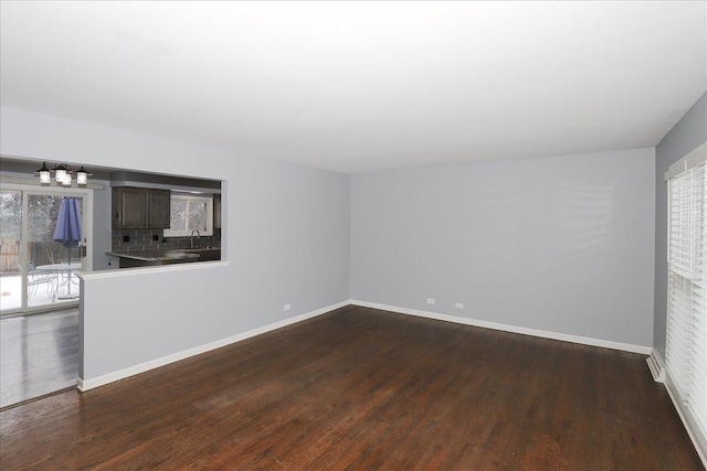 spare room featuring sink, a wealth of natural light, and dark hardwood / wood-style floors