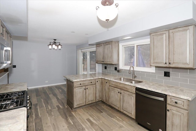 kitchen with tasteful backsplash, black dishwasher, sink, and light brown cabinetry