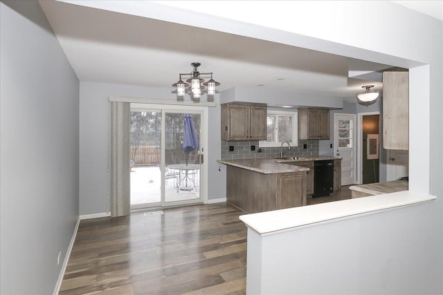 kitchen featuring dishwasher, sink, backsplash, kitchen peninsula, and dark wood-type flooring