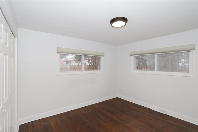 unfurnished room with dark wood-type flooring