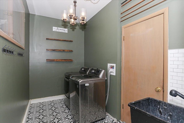 washroom featuring sink, an inviting chandelier, and washer and clothes dryer