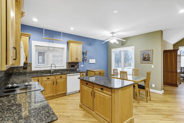 kitchen with backsplash, sink, white appliances, and a kitchen island