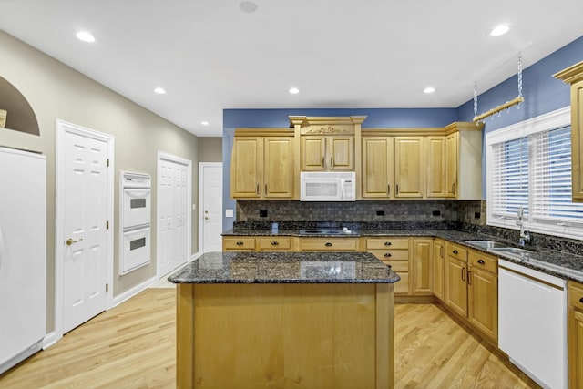 kitchen with a kitchen island, sink, light hardwood / wood-style flooring, and white appliances