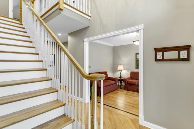 stairway featuring wood-type flooring and crown molding