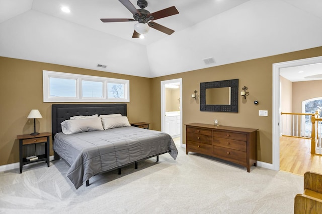 carpeted bedroom featuring ceiling fan, ensuite bath, and vaulted ceiling