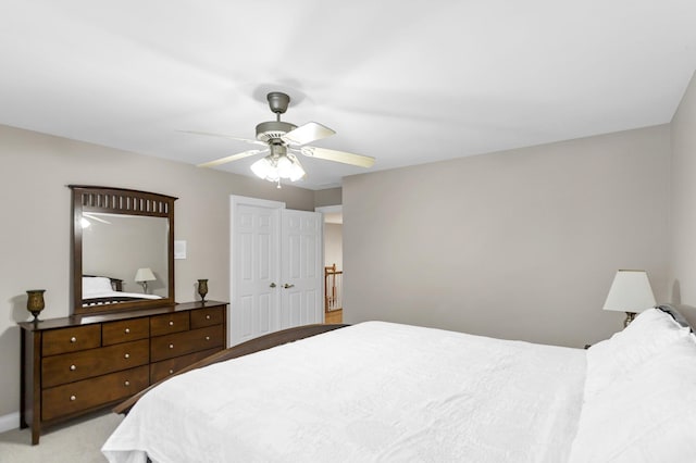 bedroom featuring ceiling fan, light colored carpet, and a closet