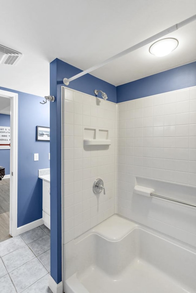 bathroom with vanity, tile patterned flooring, and a tile shower