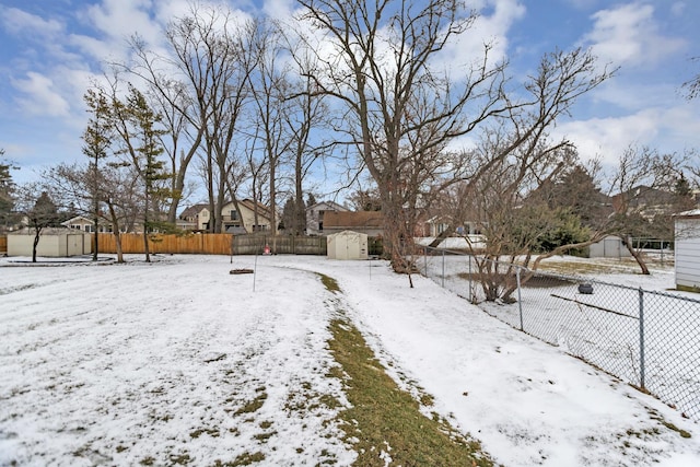 snowy yard featuring a shed