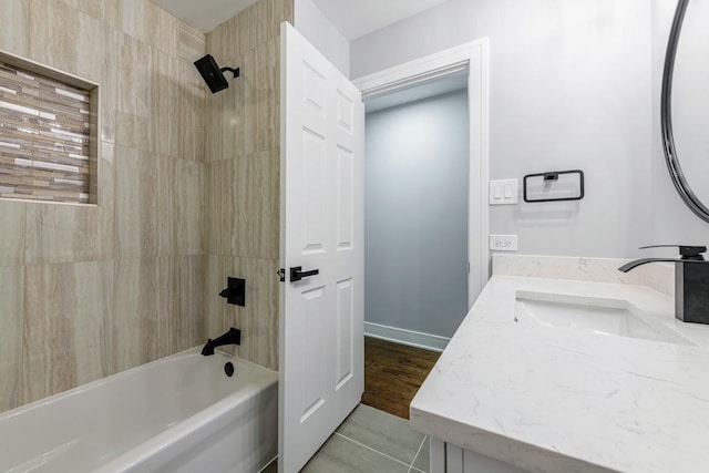 bathroom featuring tile patterned flooring, vanity, and tiled shower / bath