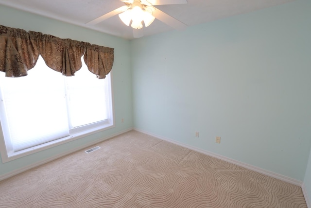 spare room with ceiling fan and light colored carpet