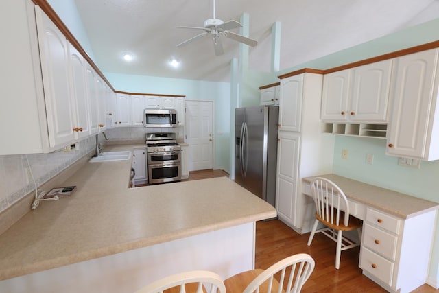 kitchen with sink, white cabinets, kitchen peninsula, and appliances with stainless steel finishes