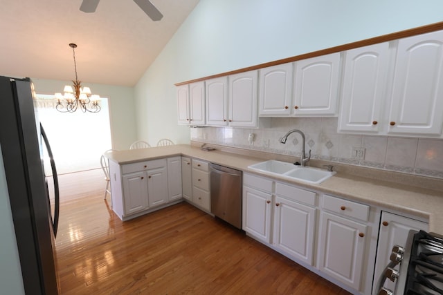 kitchen with stainless steel appliances, sink, white cabinets, decorative light fixtures, and kitchen peninsula