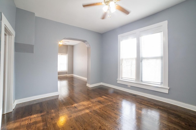 empty room with ceiling fan and dark hardwood / wood-style flooring