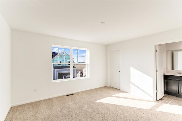 spare room featuring light colored carpet