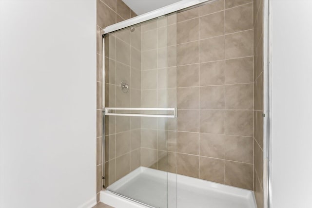 bathroom featuring a shower with shower door