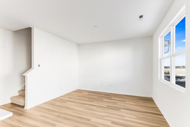 unfurnished room featuring light hardwood / wood-style floors and a wealth of natural light