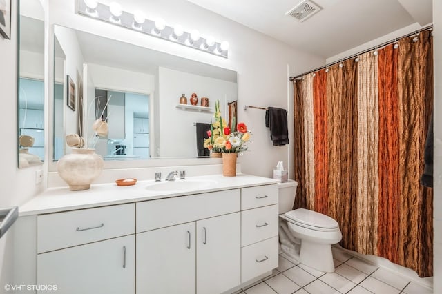 bathroom featuring tile patterned flooring, vanity, and toilet