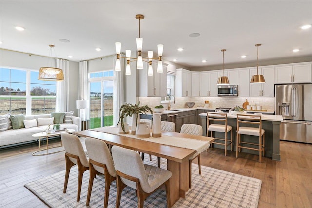 dining room with a chandelier, light hardwood / wood-style floors, and sink