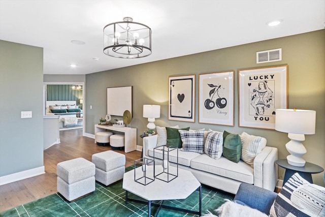 living room with dark hardwood / wood-style flooring and a notable chandelier