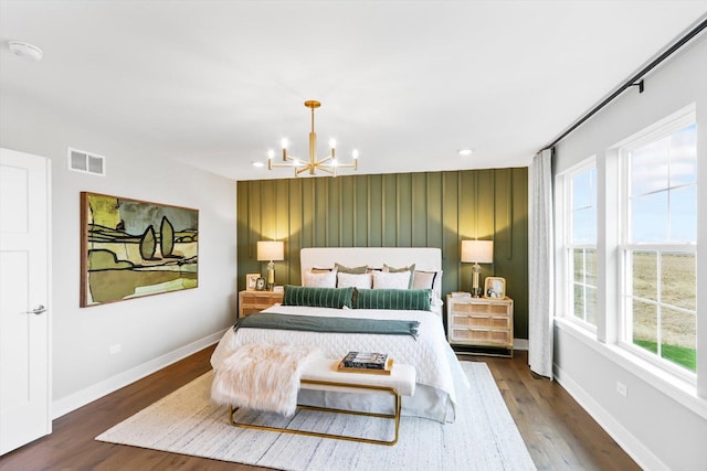 bedroom with dark hardwood / wood-style floors, multiple windows, and a chandelier