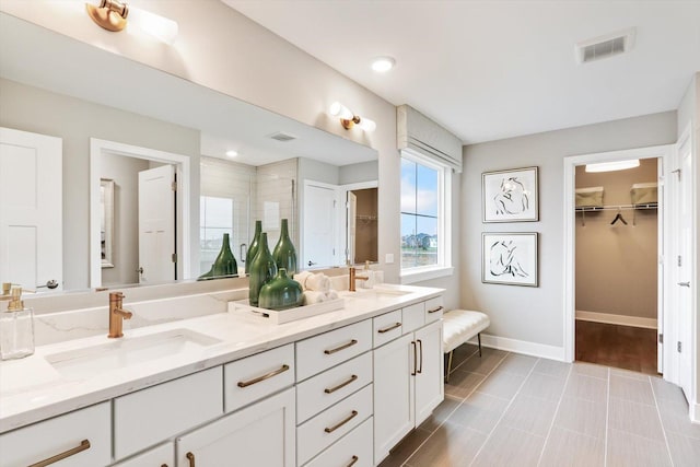 bathroom featuring tile patterned floors, vanity, and a tile shower