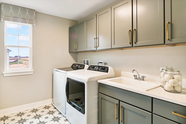 washroom with cabinets, sink, a wealth of natural light, and washing machine and clothes dryer