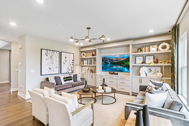 living room featuring light hardwood / wood-style flooring and a notable chandelier