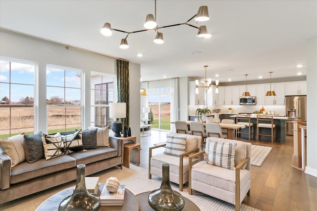 living room with light wood-type flooring and a notable chandelier