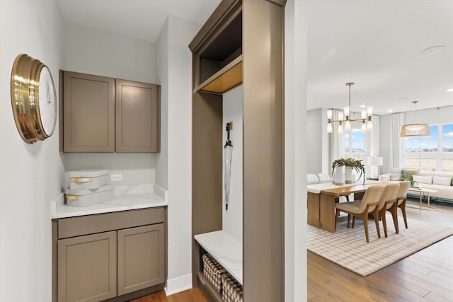 interior space featuring light stone countertops, light hardwood / wood-style floors, decorative light fixtures, and an inviting chandelier