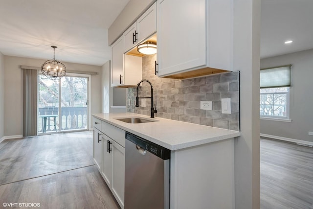 kitchen with white cabinets, dishwasher, sink, and tasteful backsplash