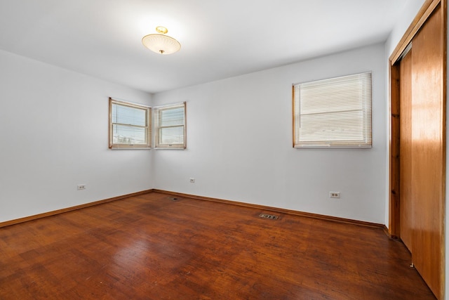 unfurnished bedroom featuring dark hardwood / wood-style floors and a closet